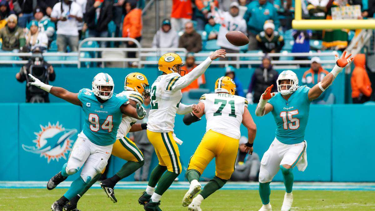 Green Bay Packers quarterback Aaron Rodgers (12) throws a pass against Miami Dolphins defensive tackle Christian Wilkins (94) and Dolphins linebacker Jaelan Phillips (15) during third quarter of an NFL football game at Hard Rock Stadium on Sunday, December 25, 2022 in Miami Gardens, Florida.