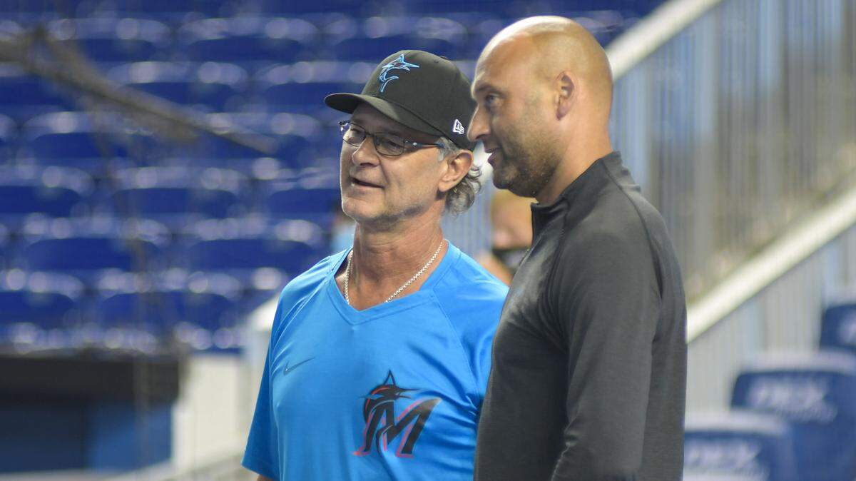 Miami Marlins manager Don Mattingly (left) and CEO Derek Jeter (right) talk on the field at loanDepot park before a game against the San Diego Padres on Saturday, July 24, 2021.