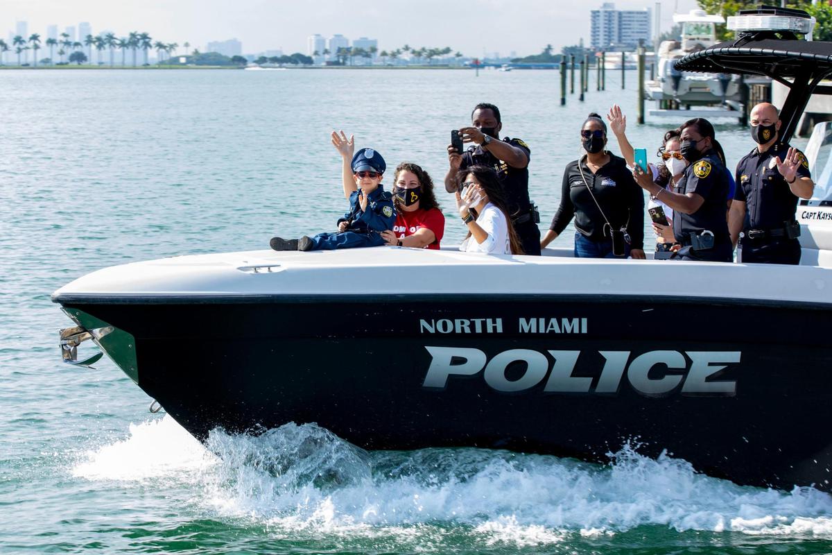 Kayson Roman, 6, diagnosed with Stage IV Neuroblastoma, waves to a crowd while riding in a police water craft with family on Friday, Jan. 7, 2022, when multiple South Florida law enforcement agencies treated him to a day on the water at Captian Kayson. The event was coordinated between the Mystic Force Foundation and North Miami Police. Kayson and family cruised around Biscayne Bay. Indian Creek, Florida Fish and Wildlife Commission, the U.S. Coast Guard, Miami-Dade Fire and Miami Fire set up in formation, giving Kayson a water salute and helicopter flyby.