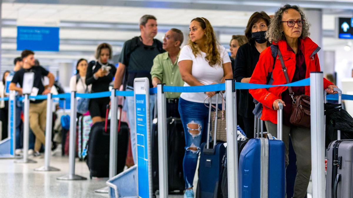 Travelers wait in lines at the departures level inside Miami International Airport in Miami, Florida, on Wednesday, Nov. 23, 2022.
