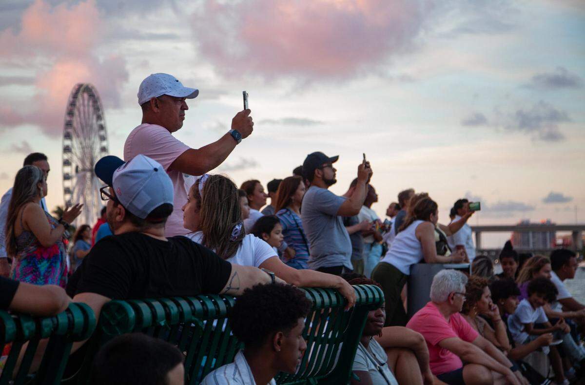 Jose Tesorero takes a photo as sunset approaches during the Fourth of July Bayfront Park Celebration at Bayfront Park on Tuesday, July 4, 2023 in Miami, Fla.