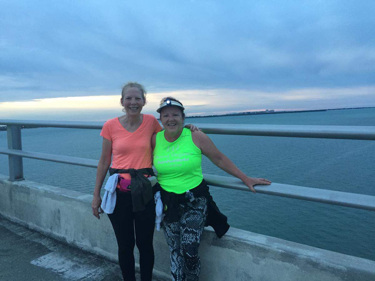 Joan Chrissos and her running partner, Alina Cruz, take a break from running across the Rickenbacker Causeway in 2015 as they train for a half marathon with TeamFootWorks.