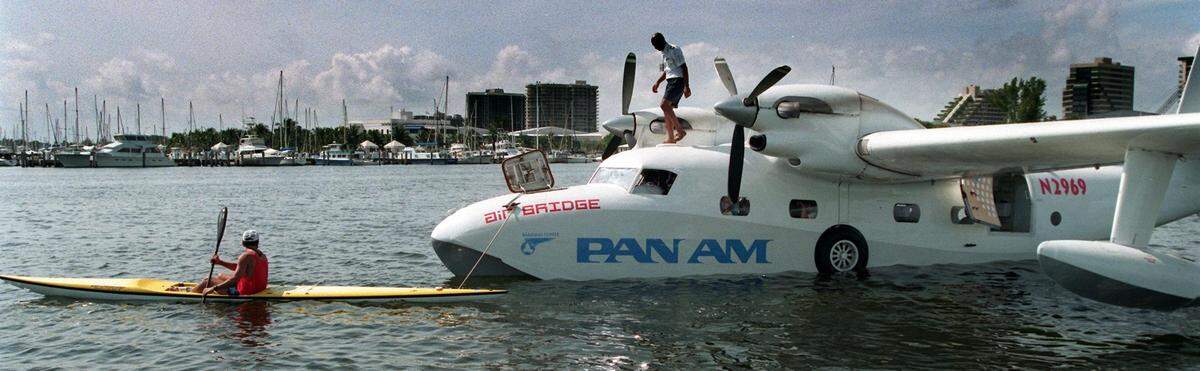 A Pan Am plane returns to the water for a 70th anniversary party at Miami City Hall, original site of Pan Am’s air base. They brought in a Grumman Mallard seaplane, which landed nearby, attracting the attention of boaters, including this kayaker.