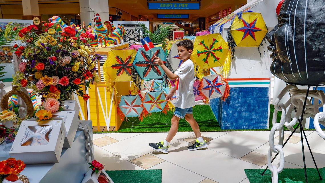 Agustin Muo, 8, walks through an exhibit by Haitian designers who are selling their Made-in-Haiti bags, jewelry, and Caribbean crafts as part of Window of Hope Haiti Art Expo at Aventura Mall in Aventura, Florida on Wednesday, September 6, 2023.
