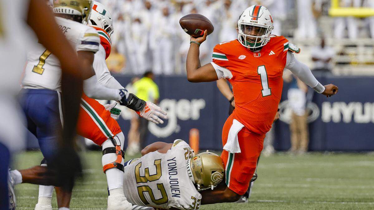Miami Hurricanes quarterback Cam Ward (1) attempts to pass the ball as Georgia Tech Yellow Jackets defensive lineman Sylvain Yondjouen (32) defends in the first half during an NCAA game at Bobby Dodd Stadium at Hyundai Field in Atlanta, Georgia on Saturday, November 9, 2024.