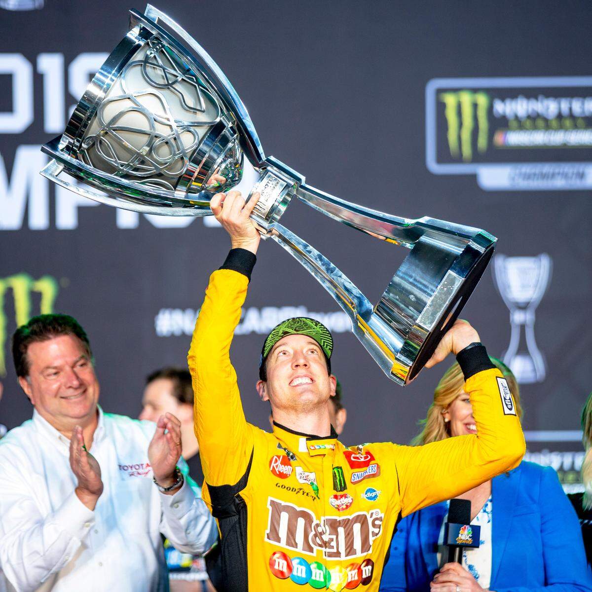 Kyle Busch (18) lifts the trophy after winning the Homestead-Miami Speedway NASCAR 21st Annual Ford EcoBoost 400 Monster Energy Series in Homestead, Florida on Sunday, Nov. 17, 2019.