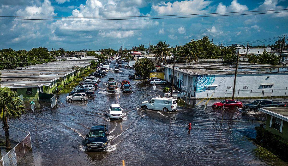 Cars gets through the water at the intersection of 7th Street and NW 15th Ave. on Thursday, April 13, 2023, as many streets in Fort Lauderdale remained flooded due to the heavy rain that affected Broward County for the last two days.