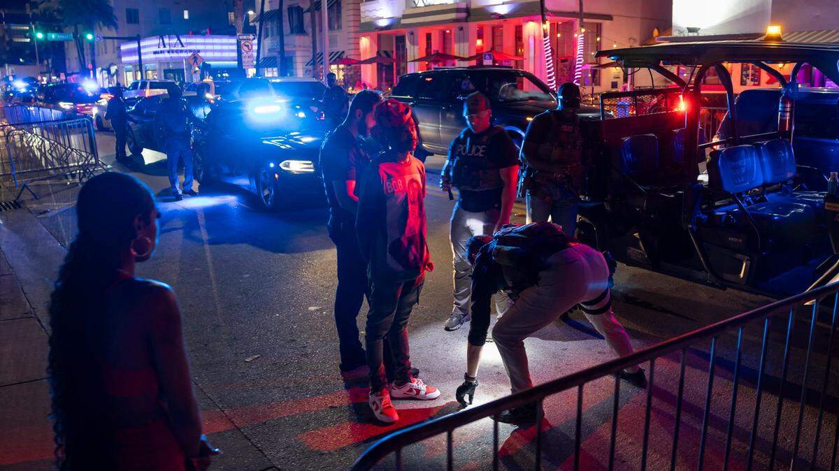 Police officers detain a man on Collins Avenue during spring break on March 15, 2024, in Miami Beach. 