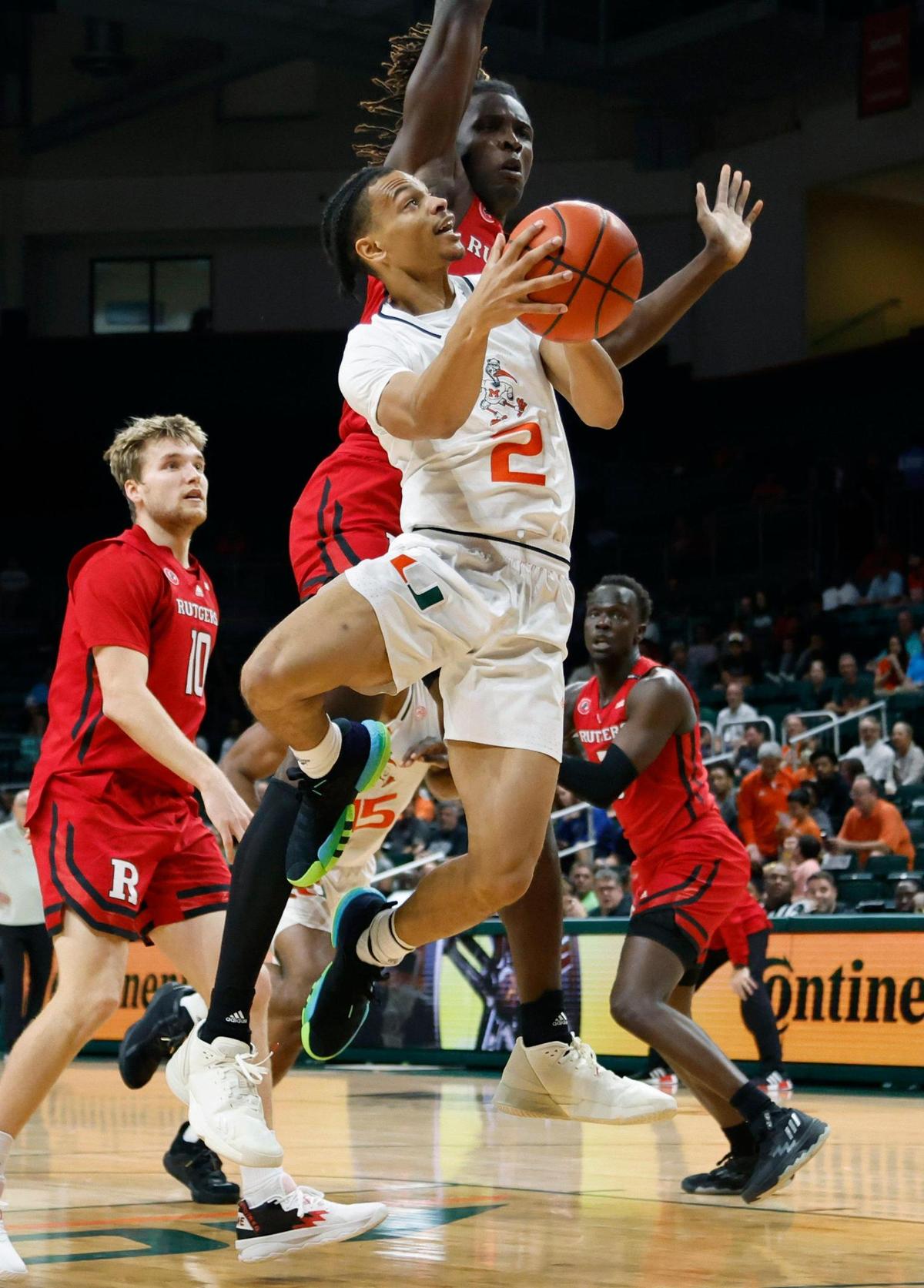 Miami Hurricanes guard Isaiah Wong (2) drives to the basket as Rutgers Scarlet Knights center Clifford Omoruyi (11) defends in the first half at the Watsco Center in Coral Gables on Wednesday, November 30, 2022.