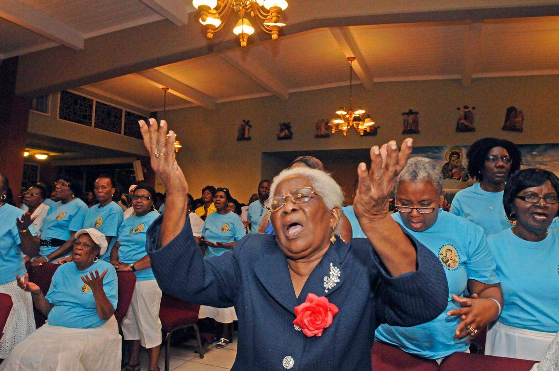 In this June 2011 photo, Marie Rose Saturne, center, and other parishioners sing during Mass at Notre Dame D’Haiti the week of its 30th anniversary.