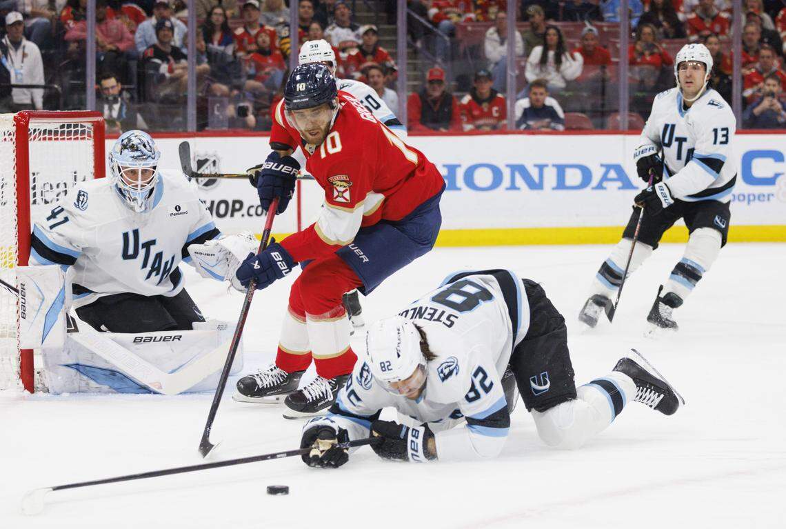 Florida Panthers left wing A.J. Greer (10) tires to keep the puck from Utah Mammoth center Kevin Stenlund (82) and goaltender Vitek Vanecek (41) during the first period of a game on Tuesday, Jan. 27, 2026, at Amerant Bank Arena in Sunrise, Fla.