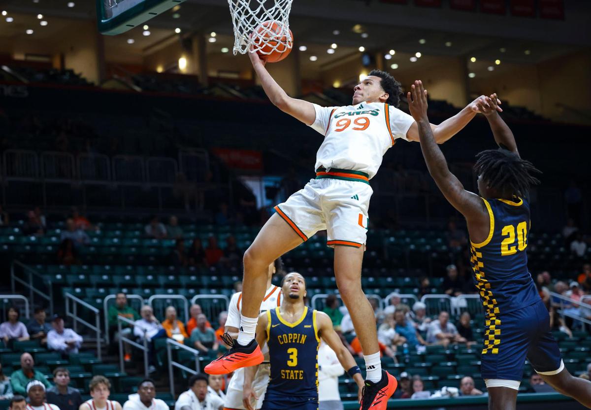 Miami (Fl) Hurricanes guard Divine Ugochukwu (99) shoots a layup over Coppin State Eagles guards Darius Leonard (20) and Cam’Ron Brown (3) during the second half of a game on Sunday, Nov. 17, 2024, at the Watsco Center in Coral Gables, Fla. The Hurricanes won 93-63.