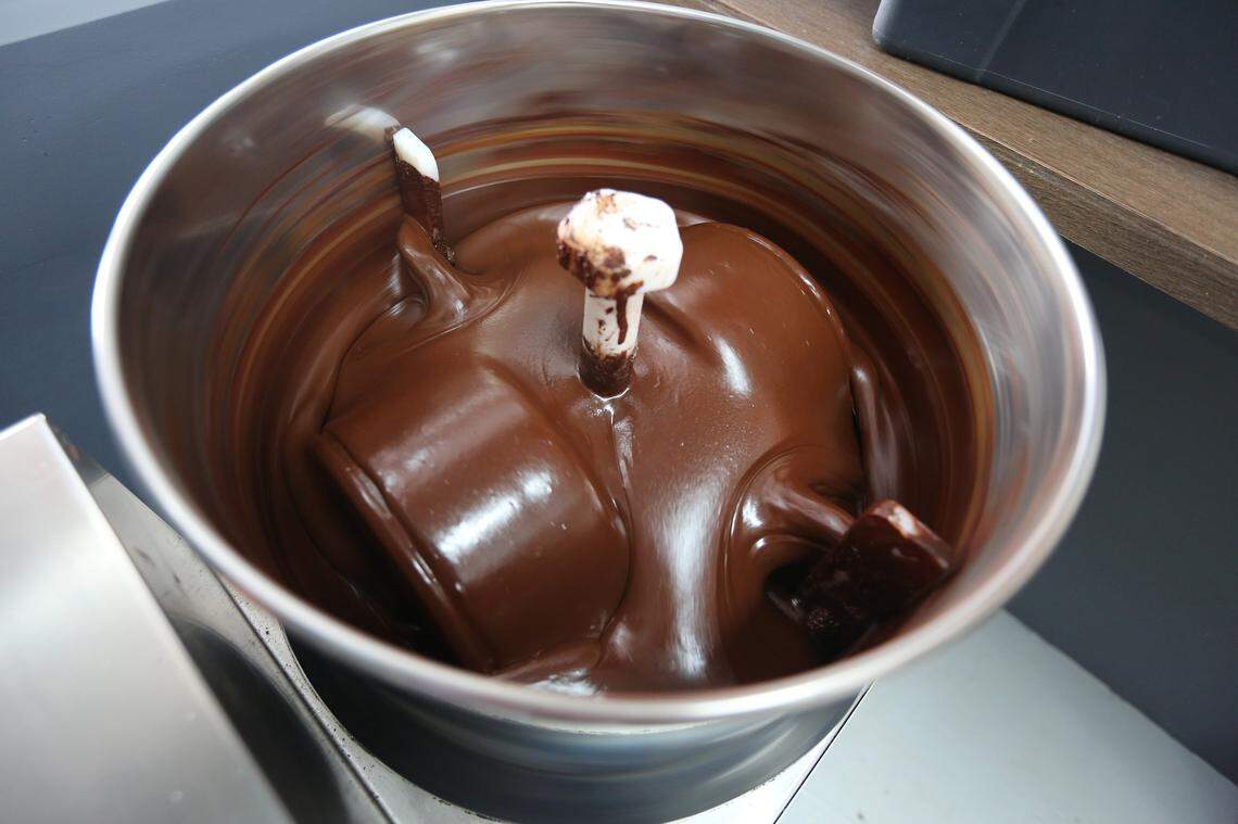 Exquisito Chocolates is opening Miami's first chocolate factory in Little Havana. Chocolate swirls inside the melanger that conches and refines it.