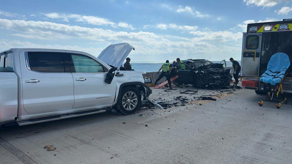 Monroe County Fire Rescue paramedics pull a person from a BMW SUV after it was involved in a head-on crash with a GMC Denali pickup truck on the Seven Mile Bridge in the Florida Keys Monday afternoon, March 3, 2025.