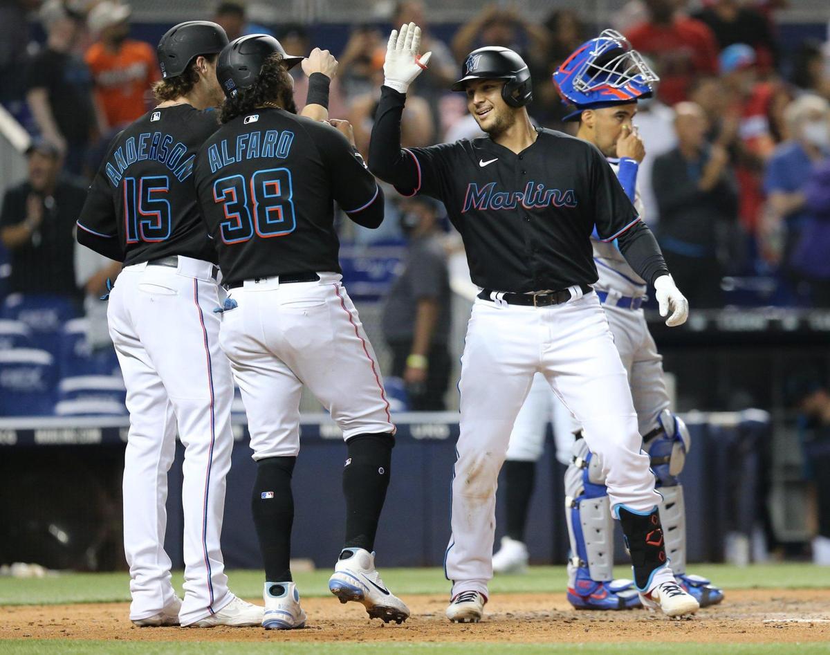 Miami Marlins catcher Alex Jackson (23) celebrates after crossing homeplate with third baseman Brian Anderson (15) and left fielder Jorge Alfaro (38) after Jackson hits a three run home run in the second inning against the Chicago Cubs during baseball game at loanDepotPark in Miami on Friday, August 13, 2021.