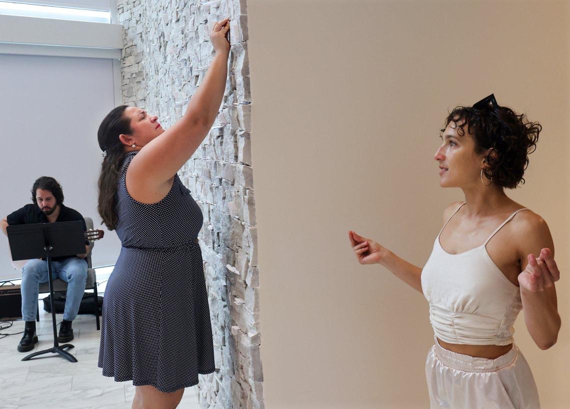 Lucy Nunez, center, squeezes a piece of paper with her prayer on the wall of stones during service at the First United Methodist Church of Miami in downtown.