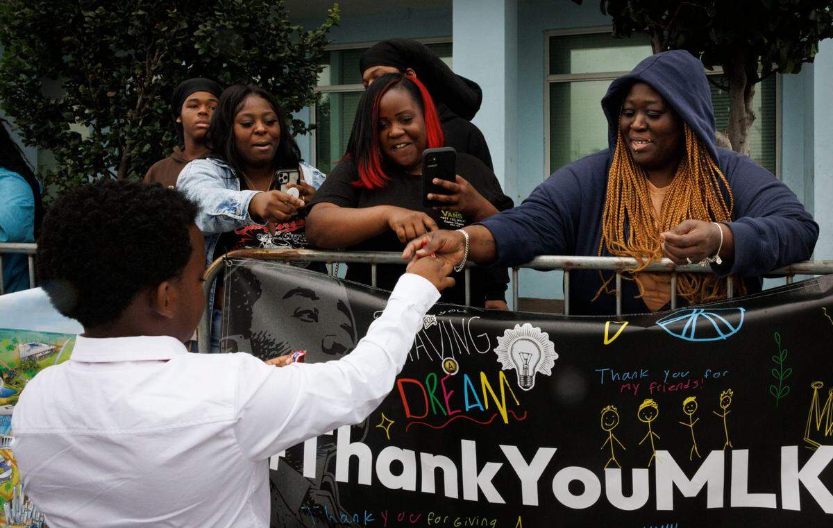 A Liberty City Elementary student gives out candy during the Dr. Martin Luther King Jr. Day parade on Monday, Jan. 20, 2025, in Liberty City in Miami, Fla.