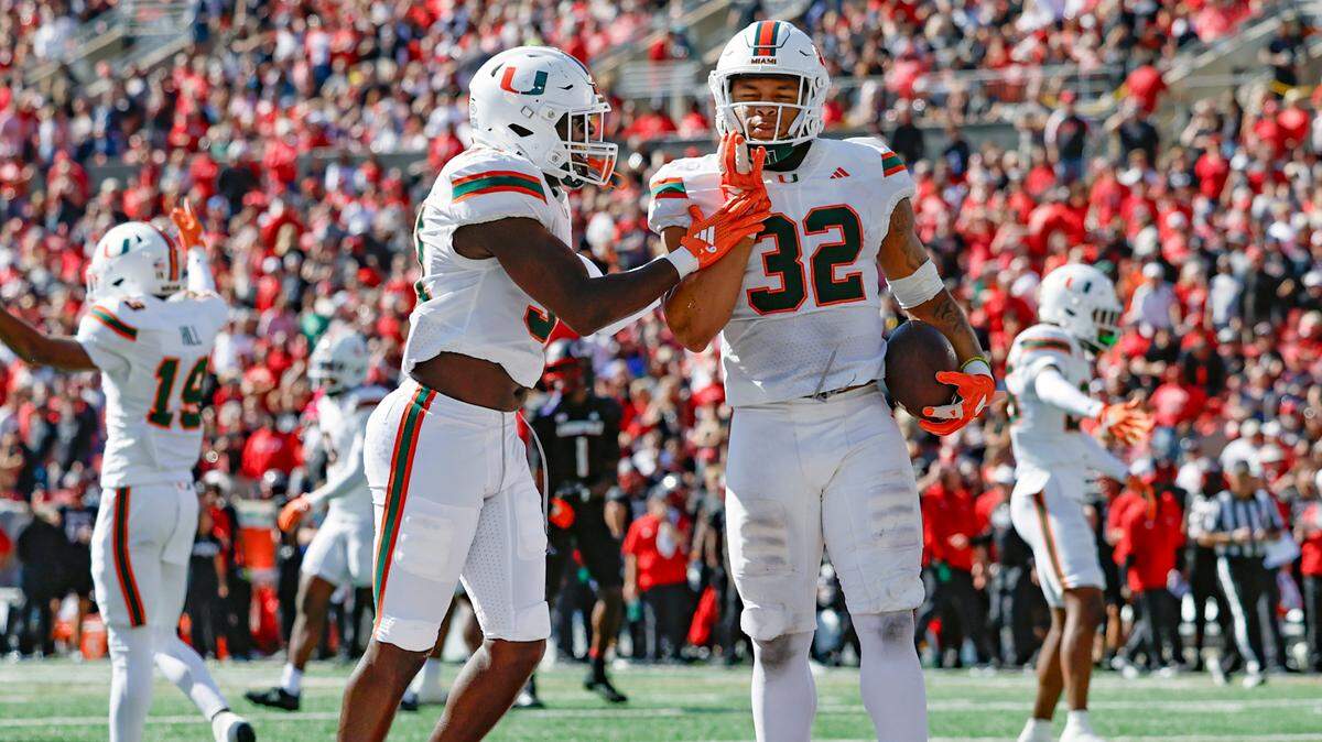 Miami Hurricanes linebacker Raul Aguirre Jr. (32) and  linebacker Wesley Bissainthe (31) celebrate Aguirre’s fumble recovery for a touchdown in the first half against the Louisville Cardinals during an NCAA football game at L&N Federal Credit Union Stadium in Louisville, Kentucky on Saturday, October 19, 2024. 
