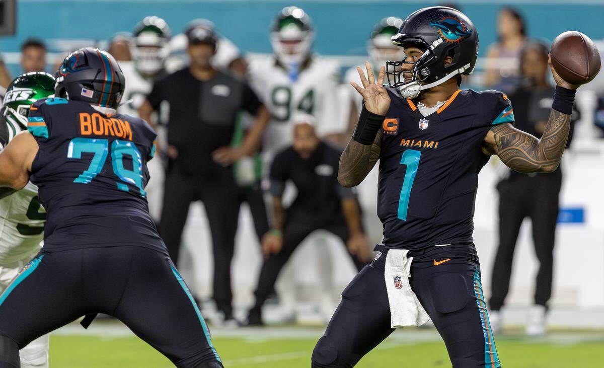 Miami Dolphins quarterback Tua Tagovailoa (1) winds up to throw as guard Larry Borom (79) blocks New York Jets defensive end Will McDonald IV (9) during the first half of an NFL game at Hard Rock Stadium on Monday, Sept. 29, 2025, in Miami Gardens, Fla.