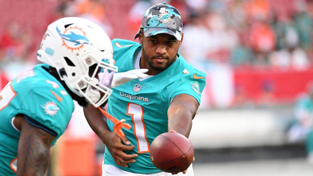 Miami Dolphins quarterback Tua Tagovailoa (1) hands off to running back ZaQuandre White (47) before an NFL preseason football game against the Tampa Bay Buccaneers Saturday, Aug. 13, 2022, in Tampa, Fla. (AP Photo/Jason Behnken)