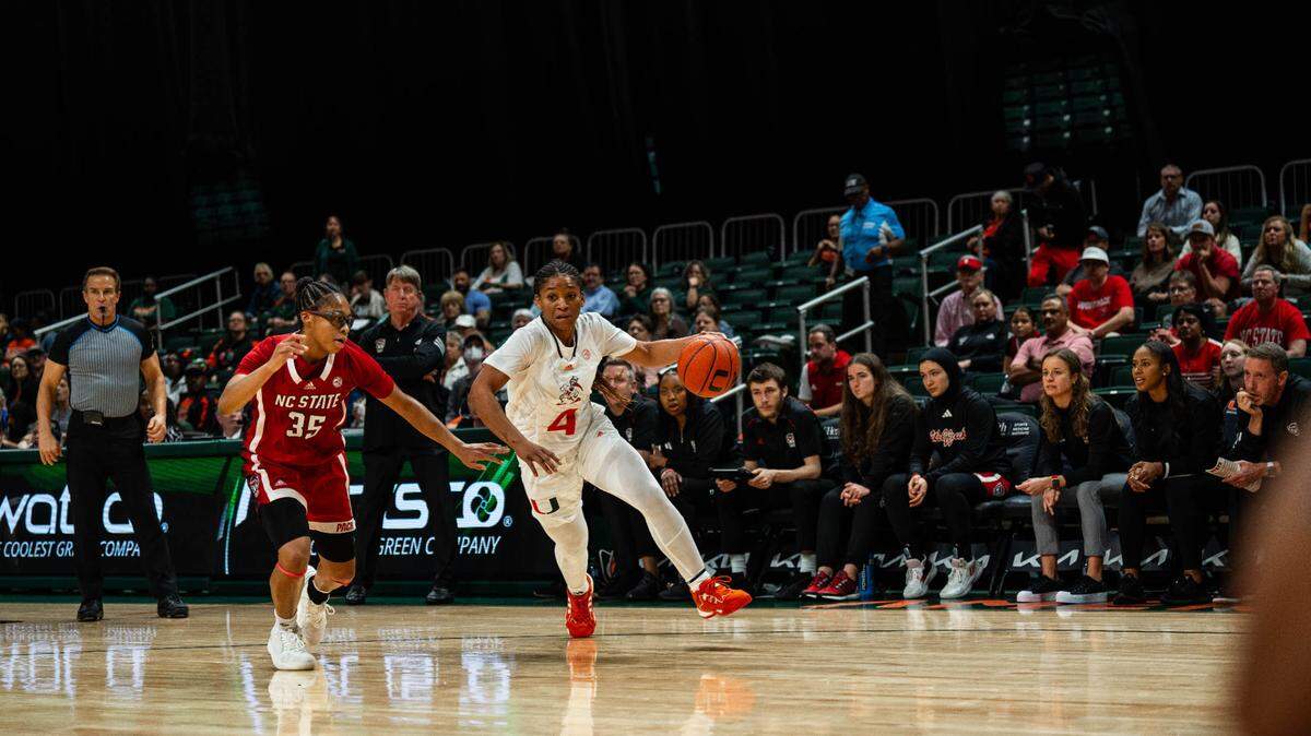 University of Miami guard Jasmyne Roberts dribbles past a North Carolina State defender in the Hurricanes’ game against the Wolfpack Thursday night at the Watsco Center. She was one of three UM players with 18 points in a 73-59 win.