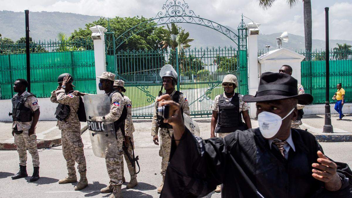 In this file photo, Haiti National Police officers stand still in front of the national palace as demonstrators march to seek justice for the murder of Monferrier Dorval, head of the bar association in the capital, Port-au-Prince, in Haiti on September 3, 2020.