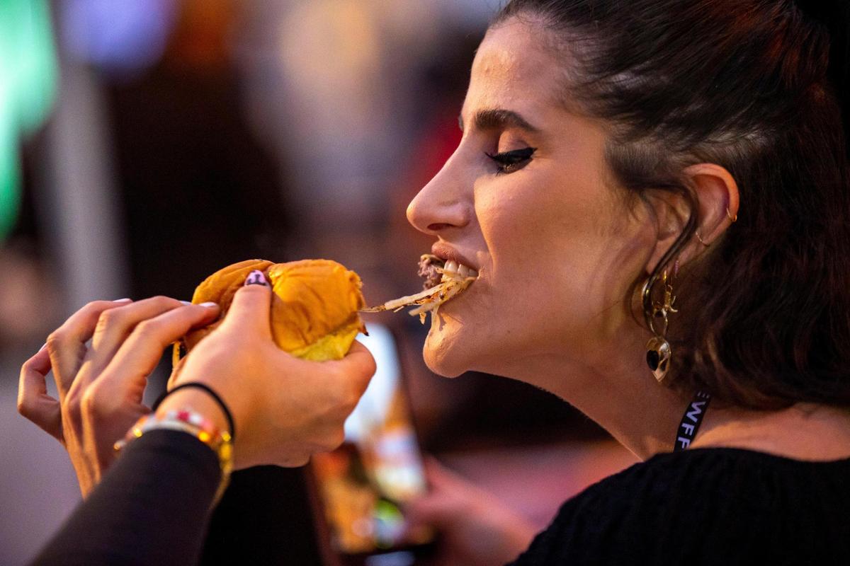 Emilie Sobel, 29, takes a bite from her friend’s burger during South Beach Wine & Food Festival’s Burger Bash.
