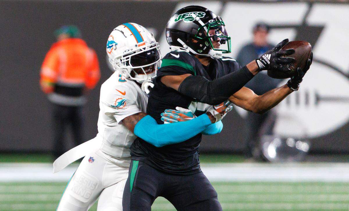 Miami Dolphins cornerback Jalen Ramsey (5) tackles New York Jets wide receiver Garrett Wilson (17) during fourth quarter of an NFL football game at MetLife Stadium on Friday, Nov. 24, 2023 in East Rutherford, New Jersey.
