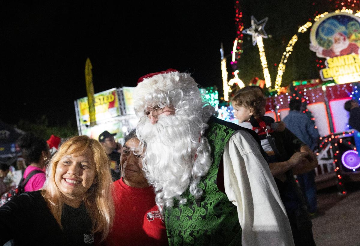 Astrid Martínez y una amiga se toman una selfie con Santa Claus durante la noche de apertura de Santa's Enchanted Forest.