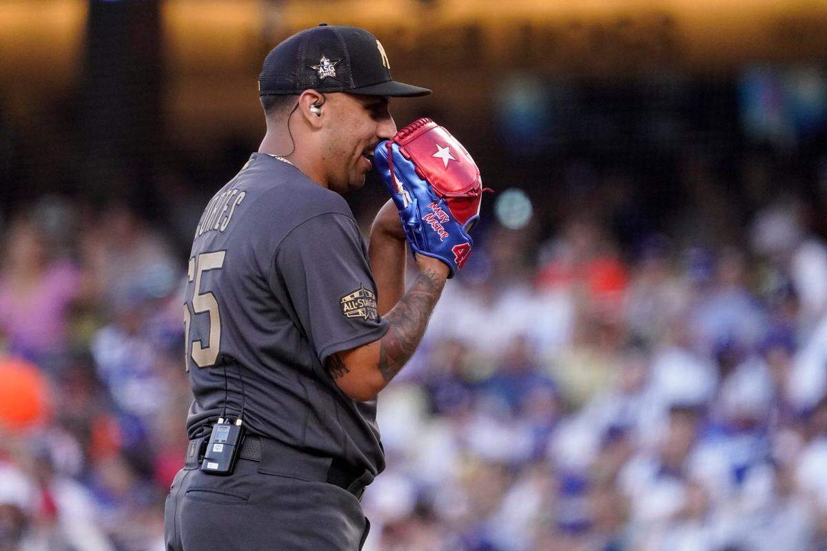 American League pitcher Nestor Cortes, of the New York Yankees, uses an earpiece and microphone to talk to his battery mate catcher Jose Trevino, also of the Yankees, betfore throwing a pitch to the National League during the sixth inning of the MLB All-Star baseball game, Tuesday, July 19, 2022, in Los Angeles.