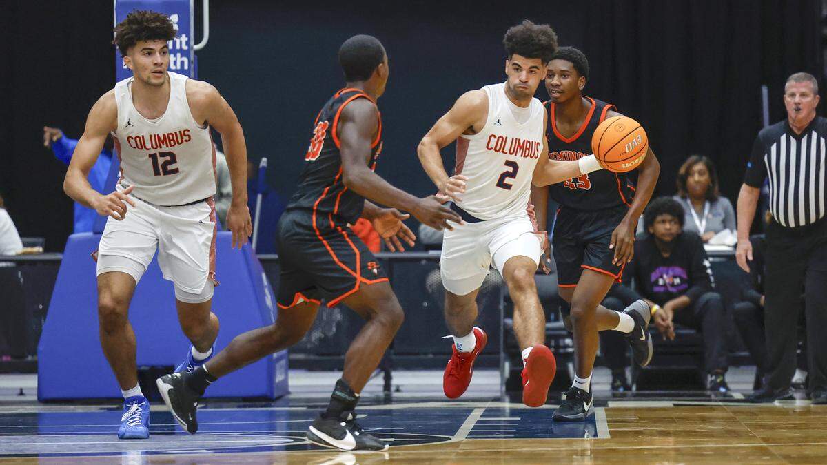 Columbus High School’s Cayden Boozer (2) drives the ball as Cameron Boozer (12) keeps watch while Seminole High School’s Javon Peterson (30) defends in the first half for the FHSAA Class 7A Semi-Final for Boys High School Basketball State Championship