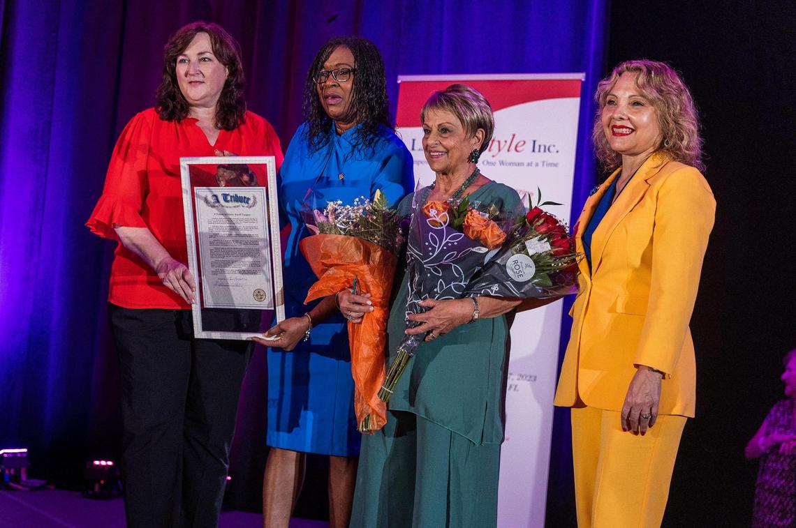  Florida state representatives, from left, Christine Hunschofsky and Marie Woodson and Dr. Rachel Tourgeman, far right, present a proclamation Friday to honor Elaine Miceli-Vasquez, founder and president of El Heraldo de Broward. 