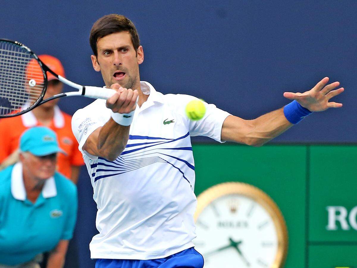 Novak Djokovic returns a ball hit by Roberto Bautista Agut in the 4th round at the 2019 Miami Open at Hard Rock Stadium in Miami Gardens, Florida, Tuesday, March, 26, 2019.