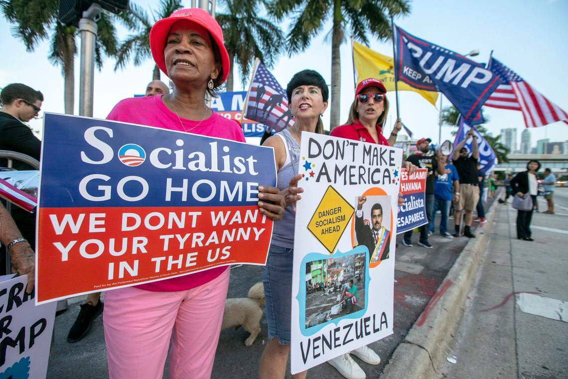 Trump supporters Linda, left, and Mina, right, chant ‘USA’ as they hold signs condemning socialist practices, outside of the Adrienne Arsht Center before the first Democratic debate in Miami, Florida, on Wednesday, June 26, 2019.