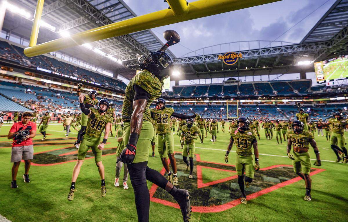 Miami Hurricanes tight end Elija Lofton (9) dunks the football over the goalpost after warmups before the game against the Stanford Cardinal for their NCAA football game at Hard Rock Stadium in Miami Gardens, Florida, on Saturday, October 25, 2025.