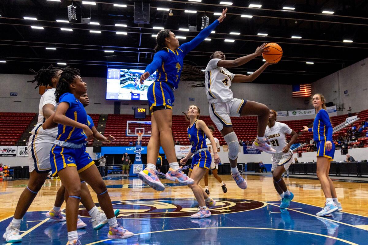 St. Thomas Aquinas guard Karina Gordon (4) lays up the ball while defended by Charlotte guard D’Yanis Jimenez (1) during the Class 6A state Girl’s basketball championship game at RP Funding Center in Lakeland, Florida, on Saturday, February 25, 2023.