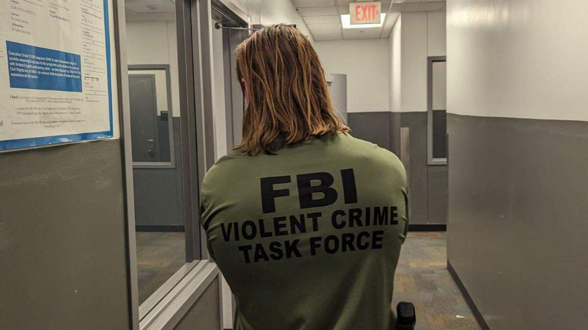 Kareem Jobbar Lightbourne, 47, is accused of killing a man in 2002 in Lauderhill, Florida, the FBI said. In the photo, an agent with FBI’s Violent Crime Task Force crosses his hands.