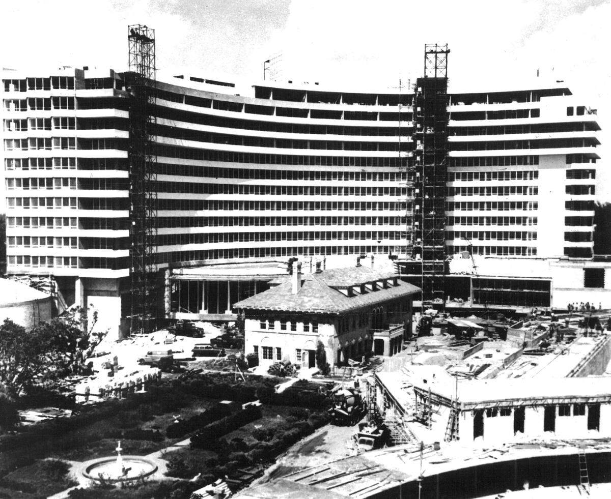 The Fontainebleau Hotel rises at the former Firestone Estate, Miami Beach. In 1954 photo, the old Harvey Firestone home is still standing in the shadow of the new $14 million building. The magnate’s estate eventually gave way to a swimming pool and landscaped gardens patterned after Versailles.