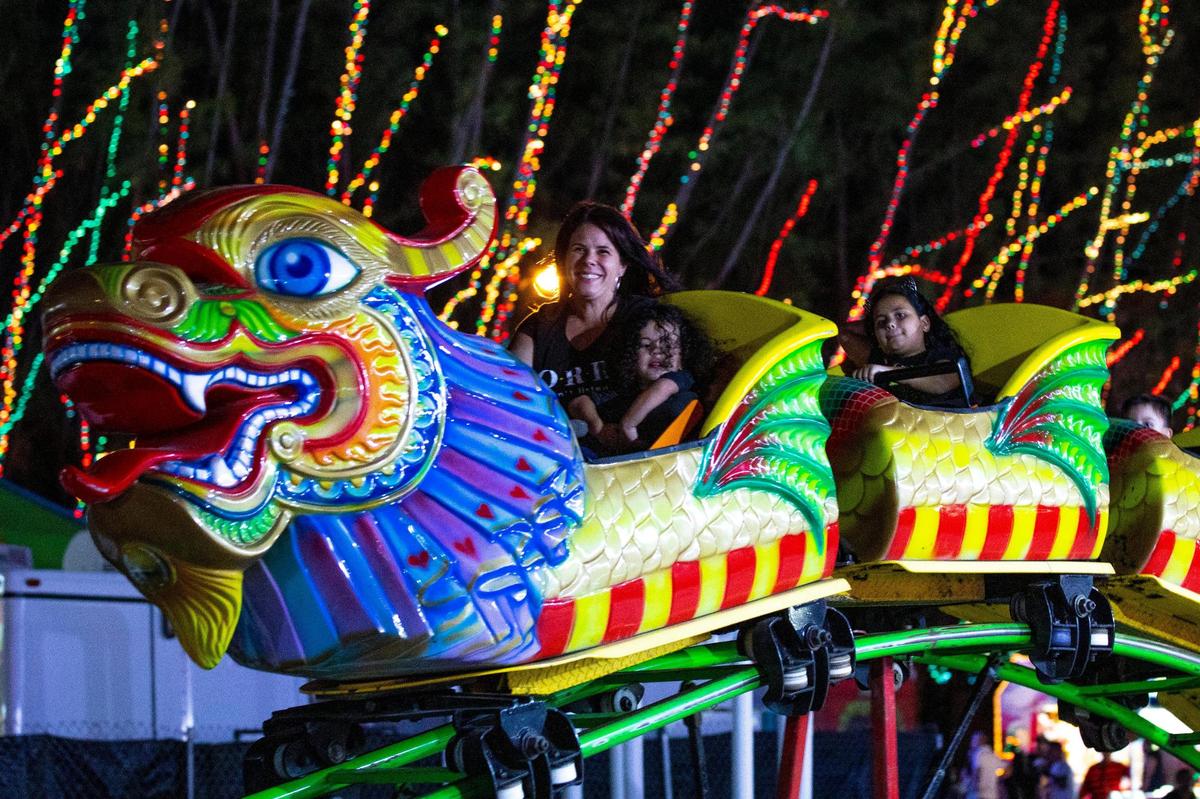 People ride a mini roller coaster inside Santa’s Enchanted Forest.