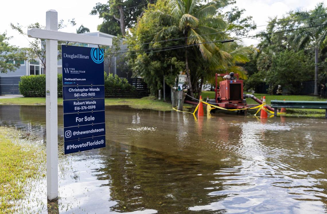 A for sale sign sticks out from a flooded street near a temporary pump at Little River Pocket Park on Monday, Oct. 30, 2023 in Miami, Fla. Monday was the highest king tide of the year for South Florida, flooding streets, driveways and parks.