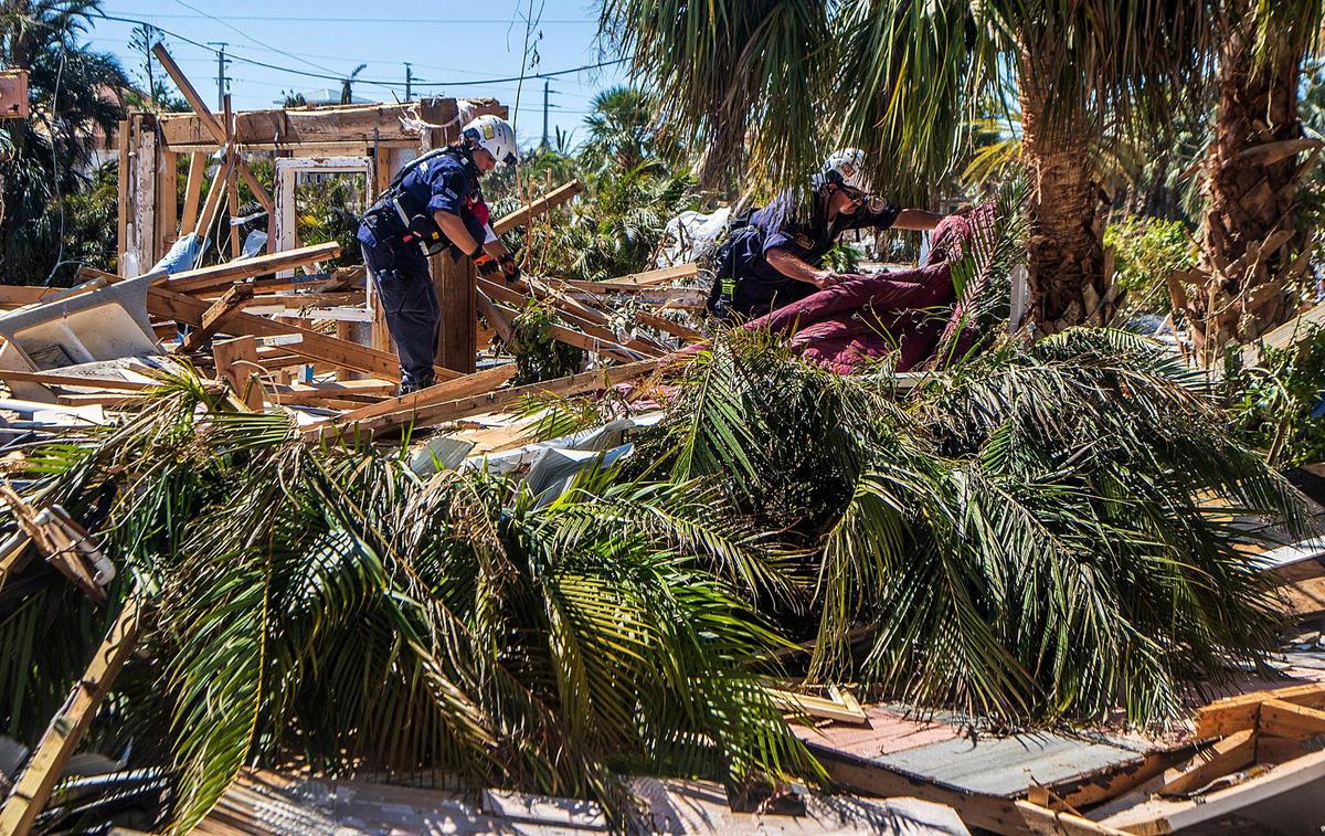 Members of a search and rescue team from Miami cover a body discovered by Pasco, a black Labrador retriever after searching the rubble on a property located at Anchorage Street in Fort Myers Beach, two days after Hurricane Ian hit Florida’s west coast as a Category 4 storm, on Friday September 30, 2022.
