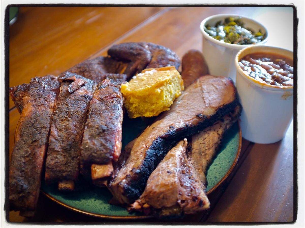 A sampling of barbecue from the Drinking Pig in Northwest Miami-Dade includes brisket, ribs, chicken and sides of baked beans and collard greens.