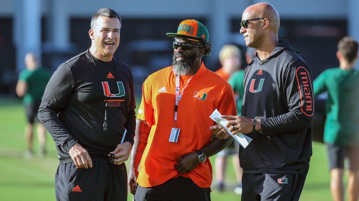 Miami Hurricanes coach Mario Cristobal talks with Pro Football Hall of Famers Ed Reed and Jason Taylor during practice drills at the University of Miamis Greentree Practice Field in Coral Gables on Thursday, March 24, 2022.