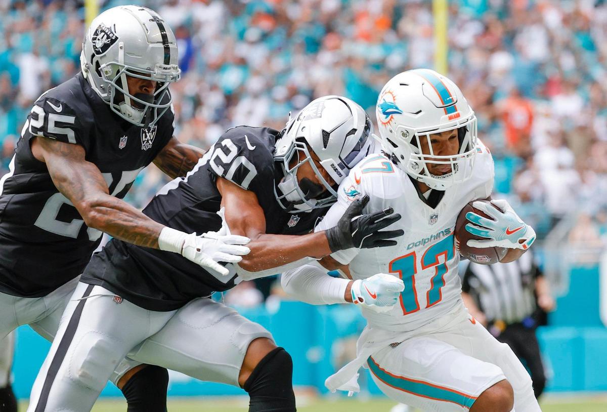 Miami Dolphins wide receiver Jaylen Waddle (17) is chased after a pass reception by Las Vegas Raiders safety Isaiah Pola-Mao (20) and Las cornerback Decamerion Richardson (25) in the first half of their NFL game in Miami Gardens, Florida on Sunday, November 17, 2024.