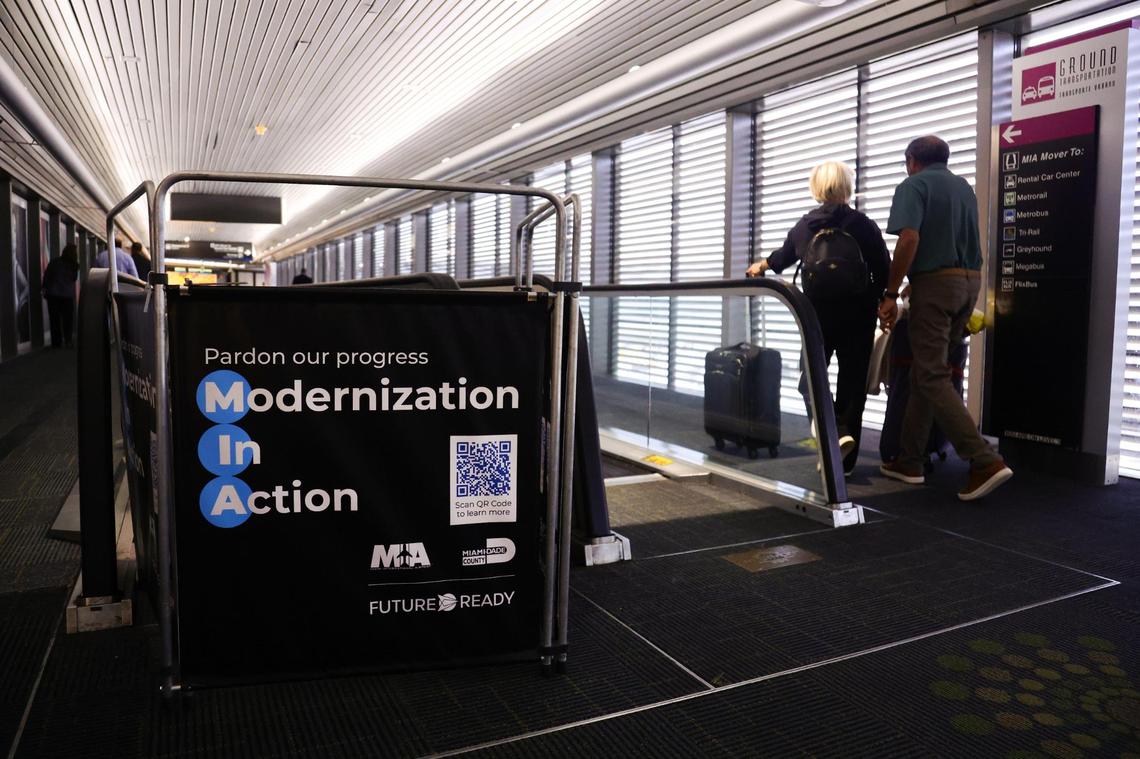 Passengers with their luggage pass by an escalator currently under repair at Miami International Airport in Miami, Florida, on Tuesday, November 12, 2024.