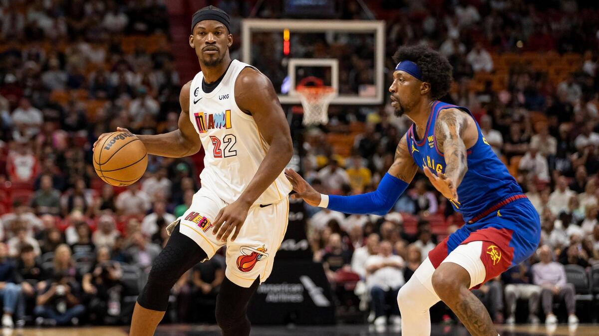 Miami Heat forward Jimmy Butler (22) dribbles while Denver Nuggets guard Kentavious Caldwell-Pope (5) defends during the first quarter of an NBA game at Kaseya Center on Monday, Feb. 13, 2023, in Miami.