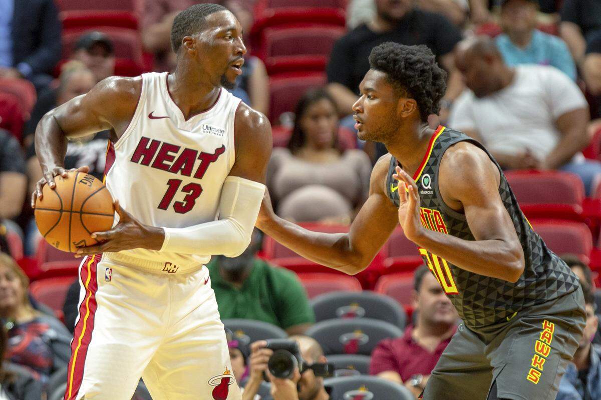 Heat center Bam Adebayo (13) keeps the ball away from Hawks center Damian Jones (30) during the third quarter of a preseason basketball game against Atlanta at AmericanAirlines Arena on Oct. 14, 2019.
