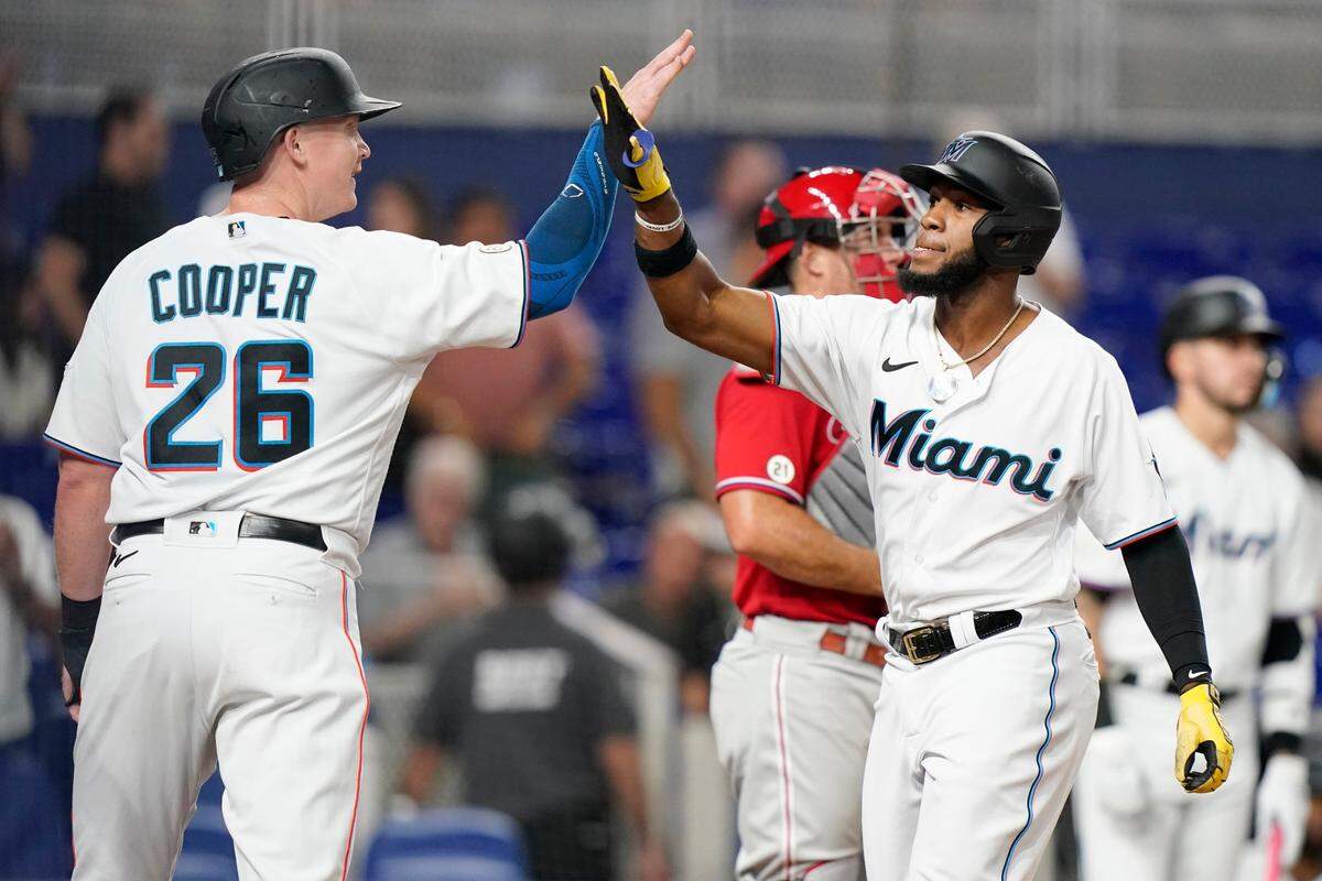 Miami Marlins’ Bryan De La Cruz, right, is met by Garrett Cooper (26) after De La Cruz scored on his three-run home run during the fourth inning of a baseball game against the Philadelphia Phillies, Thursday, Sept. 15, 2022, in Miami. (AP Photo/Lynne Sladky)