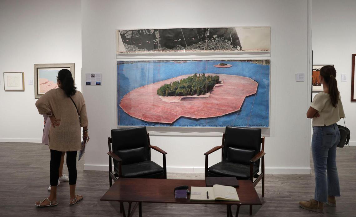 Two people admire ‘Surrounded Islands’ by Christo and Jeanne-Claude inside the Archeus/Post Modern gallery booth during the opening night of VIP for Art Miami on Tuesday, Nov. 29, 2022, at CONTEXT Art Miami.