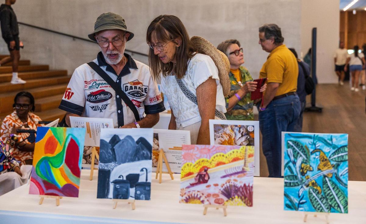 Artists Rolando Sanchez (left) and Mo Cooling check pieces on display at the Pérez Art Museum Miami’s Creative Aging Series: Spring Painting Showcase of art created during the free art-making program for individuals over the age of 55.